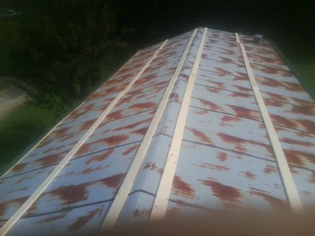 Rusted metal roof panels with new wood purlins before replacement — Storm Damage Roof Repair in Kenansville by Roofing Brothers